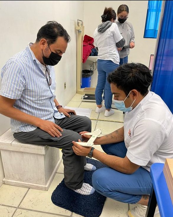 Medición del perímetro de la pantorrilla con cinta métrica durante una consulta de nutrición